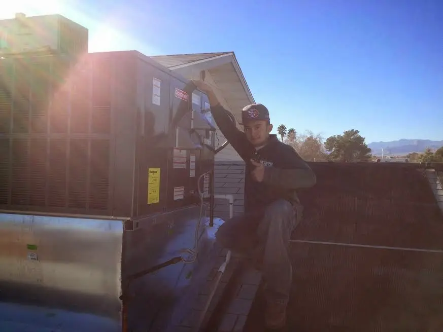 HVAC technician performing Heat Pump Repair on a rooftop unit in St. Marys
